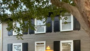 A two-story house with a front porch, a small tree, and a well-maintained garden. - In-Town Lewes, Private Getaway! 4 BDRM,2.5BA. Steps to 2nd Street and Bike Trail (Lewes)