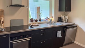 A modern kitchen with a built-in oven, dishwasher, and a window with a view of the outside. - 7 bedroom amazing home in Nedre Vats (Nedre Vats)