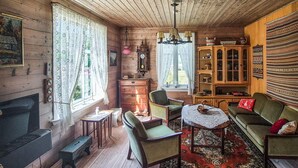 Une pièce chaleureuse avec une cheminée, des meubles en bois et un tapis à motifs.