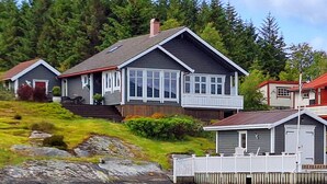 A two-story house with a balcony, a garage, and a dock. - Cozy home in Florø with WiFi (Florø)
