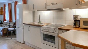 A compact kitchen with white cabinets, a stove, a sink, and a microwave. - Stunning home in Eidsvåg i Romsdal (Eidsvåg i Romsdal)