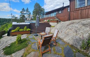En uteplats med ett bubbelbad, utomhusmöbler och en gångstig av sten.