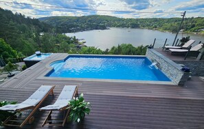 Piscina com vista para um lago e uma floresta.