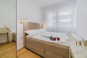 Une chambre d’hôtel bien rangée, avec un lit, une table de chevet et un bureau.