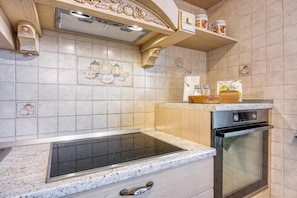 A kitchen with a built-in stove, oven, and a wooden countertop.