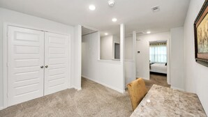 Una habitación con una mesa de comedor, una silla, una cama y una puerta.