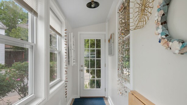 A narrow hallway with white walls, a blue carpet, and a door leading outside. - Adorable Seaside Cottage (Old Orchard Beach)