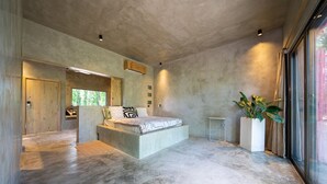 Un dormitorio moderno con una cama grande, una puerta de madera y un ventanal amplio.