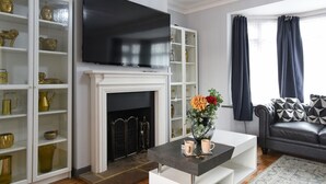 Un salon moderne avec une cheminée, un téléviseur et un canapé.