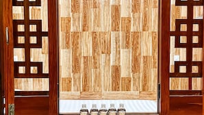 A conference room with a table set for a meeting, wooden panel walls, and a view through the window.