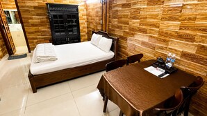 A hotel room with a bed, a wooden wardrobe, a table with chairs, and a tiled floor. - Pho Thien Duong Homestay (Hue)