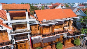 Monikerroksinen rakennus, jossa on punatiilestä tehty katto, puiset parvekkeet ja perinteinen arkkitehtoninen tyyli.