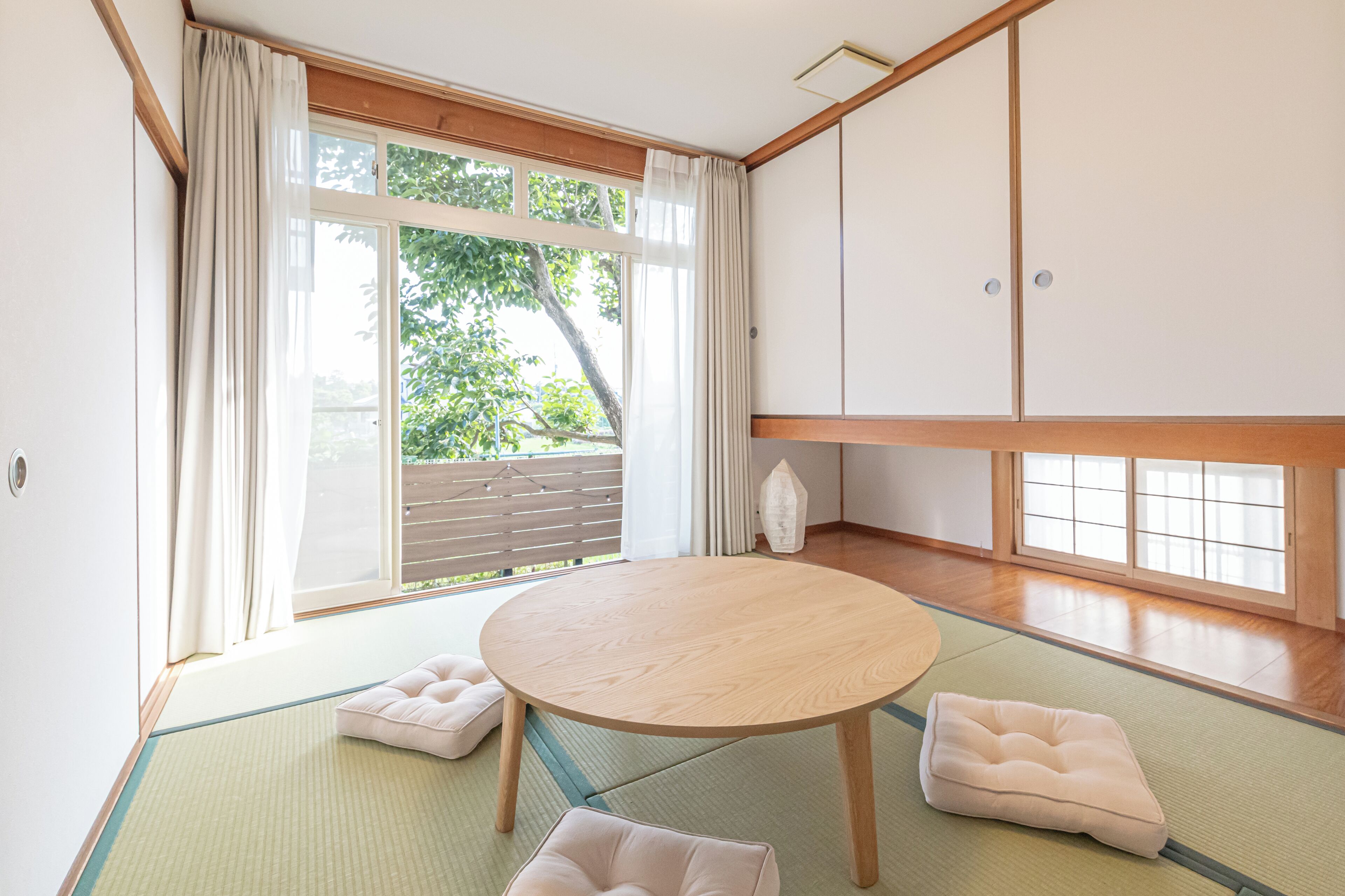 A traditional Japanese room with tatami flooring, a tatami mat table, and a low wooden cabinet.