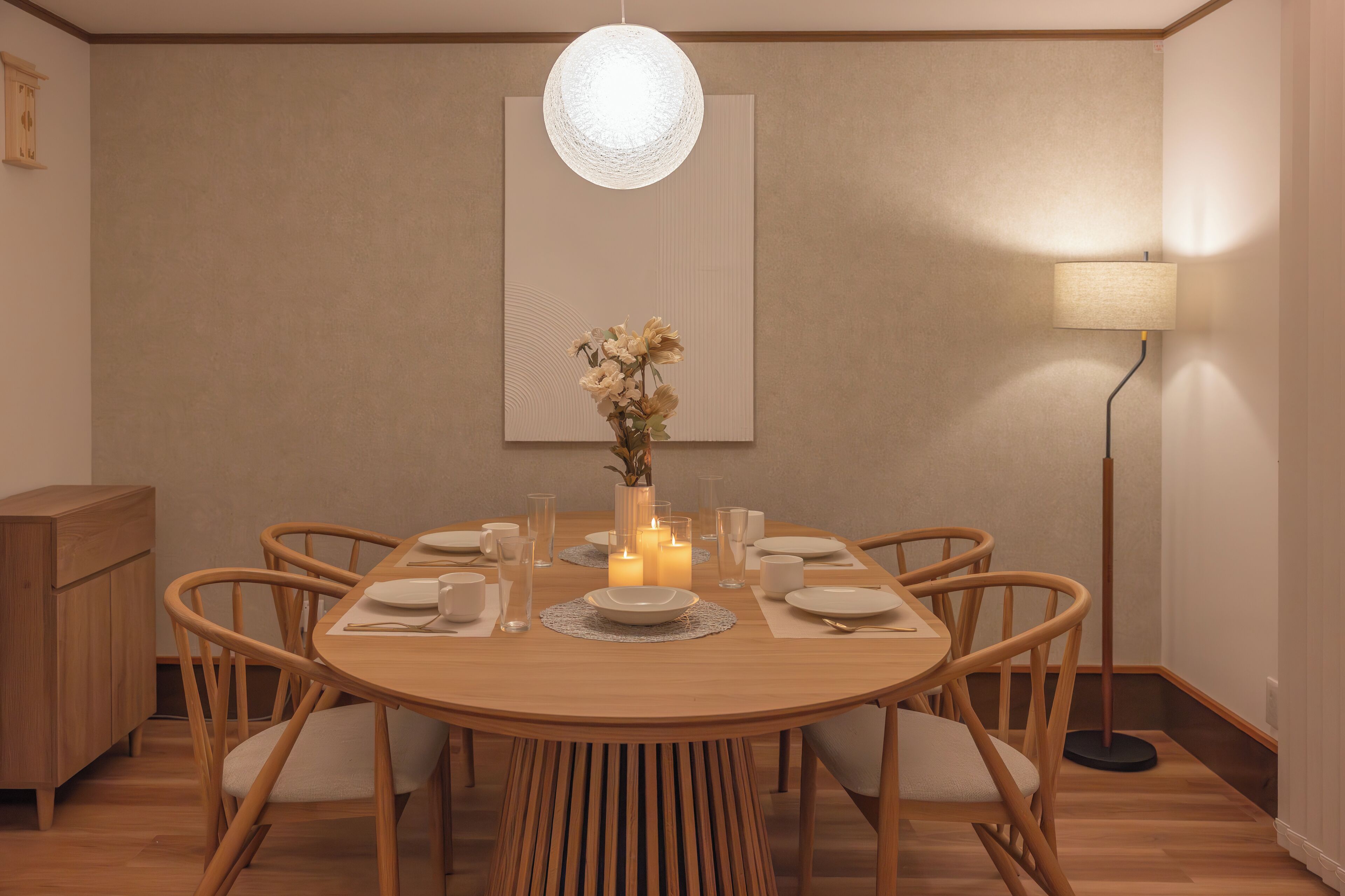 Comedor con una mesa de madera redonda dispuesta para seis personas, rodeada de sillas de madera.