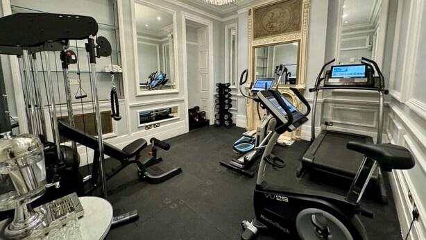 A gym with treadmills, elliptical machines, and weightlifting equipment.