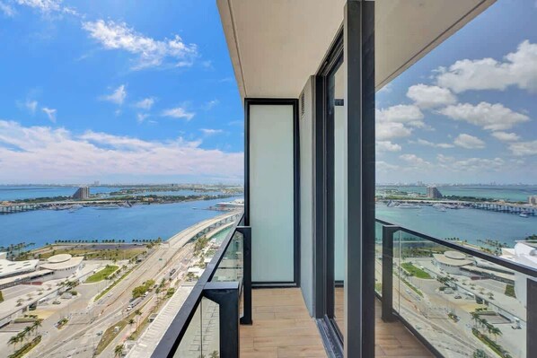 A balcony with a view of a coastal cityscape, including a bridge and water.