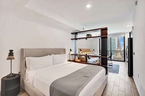Une chambre d’hôtel moderne dotée d’un grand lit, d’un bureau, d’une chaise et d’un balcon offrant une vue sur la ville.