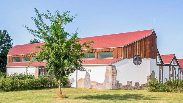 A large barn-style building with a red roof, white walls, and stone accents. - 9 Person Holiday Park Home in Otterup (Otterup)