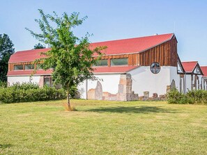 A large barn-style building with a red roof, white walls, and stone accents. - 9 Person Holiday Park Home in Otterup (Otterup)