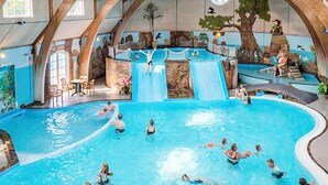 An indoor swimming pool with multiple lanes, a slide, and a seating area with tables and chairs. - 9 Person Holiday Park Home in Otterup (Otterup)