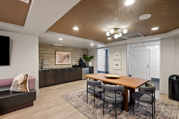 A modern kitchen with a wooden countertop, dark cabinets, and a built-in stove.