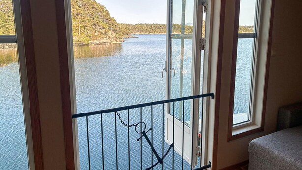 A room with a view of a lake and forest through a glass door. - Beautiful home in Lepsøy with WiFi (Lepsøy)