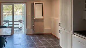A kitchen with a tiled floor, a built-in oven, and a window overlooking a deck. - Beautiful home in Lepsøy with WiFi (Lepsøy)