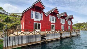 A red wooden house with a dock extending into a body of water. - Beautiful home in Lepsøy with WiFi (Lepsøy)