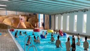 An indoor swimming pool with multiple lanes, a diving platform, and a rock formation in the background. - 6 Person Holiday Park Home in Fjerritslev (Fjerritslev)