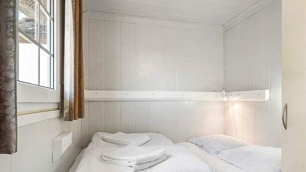 A small, single-bed room with white walls and a window with curtains. - 6 Person Holiday Park Home in Fjerritslev (Fjerritslev)