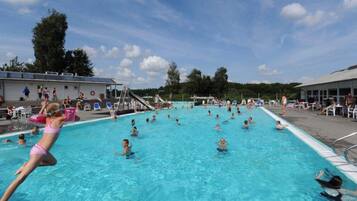 A swimming pool with multiple lanes, a lifeguard tower, and a covered seating area.