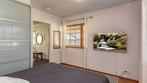 A bedroom with a bed, a TV mounted on the wall, and a window with blinds. - Levin alppi 3 b 7 by Interhome (Kittilä)