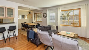 A modern living room with a sofa, chairs, a dining table, and a kitchen area with cabinets and a window with blinds. - Levin alppi 3 b 7 by Interhome (Kittilä)