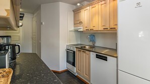 A modern kitchen with white cabinets, a stainless steel sink, and a built-in dishwasher. - Levin alppi 3 b 7 by Interhome (Kittilä)