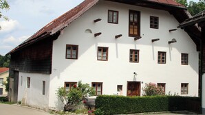Un grand bâtiment blanc, doté d’un toit rouge à forte pente et de nombreuses fenêtres.