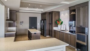 Una cocina moderna con una isla central, electrodomésticos integrados y una planta decorativa.