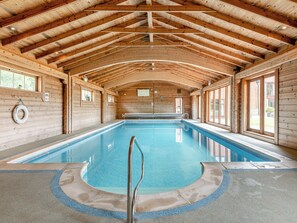 An indoor swimming pool with wooden walls and a high ceiling. - 2 bedroom accommodation in Blandford Forum (Blandford Forum)