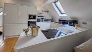 A modern kitchen with a central island, built-in appliances, and a skylight.