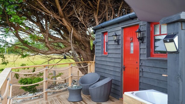 A wooden deck with a rope bridge, a red door, and a bathtub. - Ty'r Bugail Shepherds Hut (Tal Y Bont, near Barmouth)