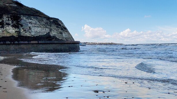 A beach with a rocky cliff and waves. - 3 bedroom accommodation in Roker, near Sunderland (Roker, near Sunderland)