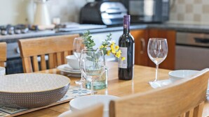 A dining table set with plates, bowls, wine glasses, and a bottle of wine. - 3 bedroom accommodation in Roker, near Sunderland (Roker, near Sunderland)