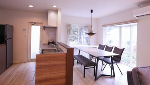 Una cocina moderna con comedor, ventanas amplias y un banco empotrado.
