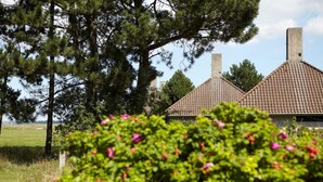 A house with a tiled roof, surrounded by trees and greenery. - 4 Person Holiday Park Home in Karrebaeksminde (Karrebæksminde)