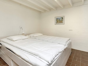 A single-bed room with white bedding, a bedside lamp, and a small framed picture on the wall. - 4 Person Holiday Park Home in Karrebaeksminde (Karrebæksminde)