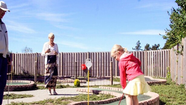 A miniature golf course with a wooden fence and a small pond. - 6 Person Holiday Park Home in Skagen (Skagen)