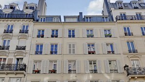 A row of multi-story buildings with white facades and balconies. - The Upper Marais Superb Apartment for 6 People (Paris)