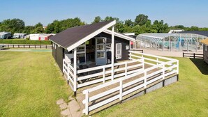 Een klein, laag gebouw met een overdekt terras en een omheind terras.