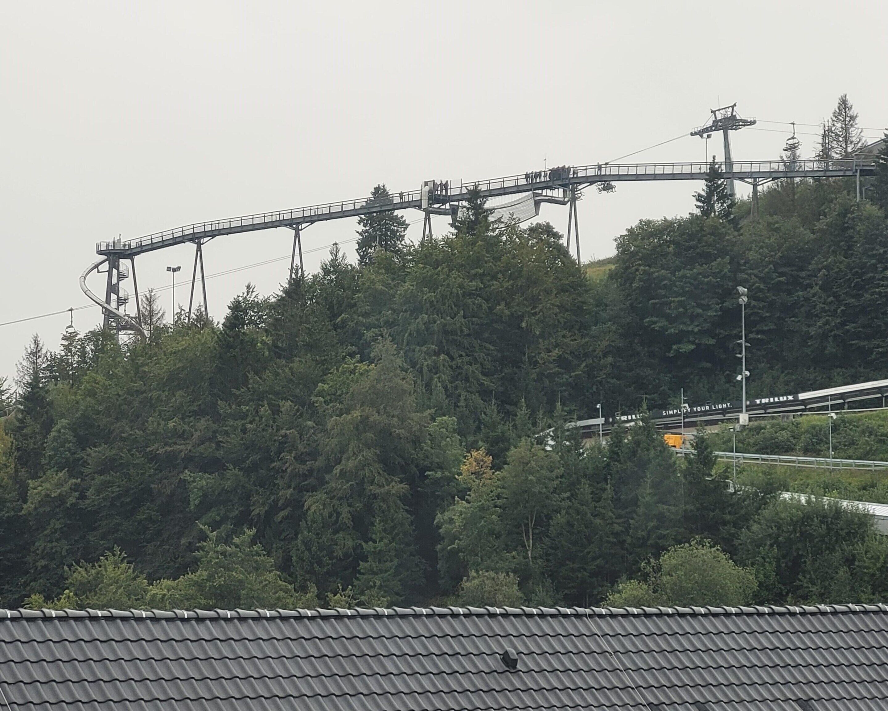 A cable car system on a mountain with a forested backdrop.