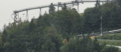 A cable car system on a mountain with a forested backdrop.
