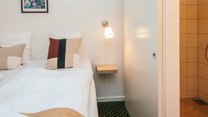 A hotel room with a bed, a bedside table with a lamp, and a framed photo on the wall. - 2 Person Holiday Park Home in Fano (Fano)